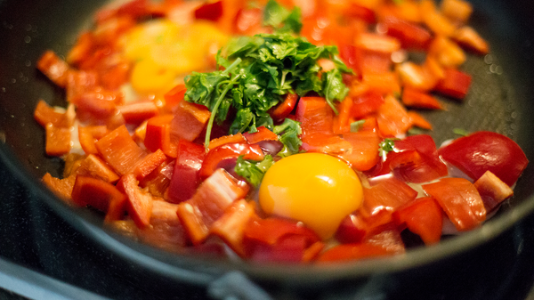 Mixing peppers, tomatoes and eggs
