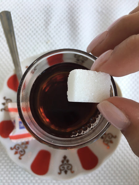 Adding sugar cube to Turkish tea